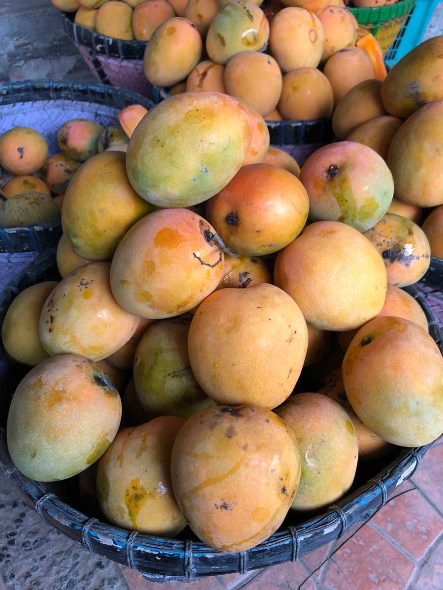 道端で売られているかごに山盛りのマンゴー